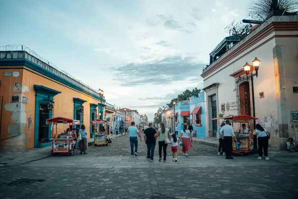Cobblestone street in Oaxaca's Jalatlaco neighborhood with painted buildings and a small café table