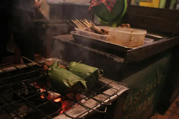 Steaming bowl of sopa de pan and tamales wrapped in banana leaf at a Chiapas market stall