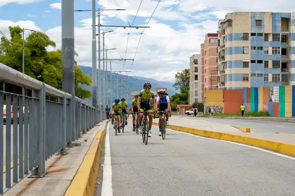 Sunday Ciclovía in Medellín with cyclists, families, and skaters filling a wide closed avenue lined with palms and green hillsides in the background