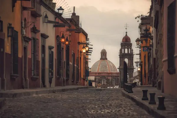 Cobblestone street in San Cristóbal de las Casas at dusk with pastel colonial buildings