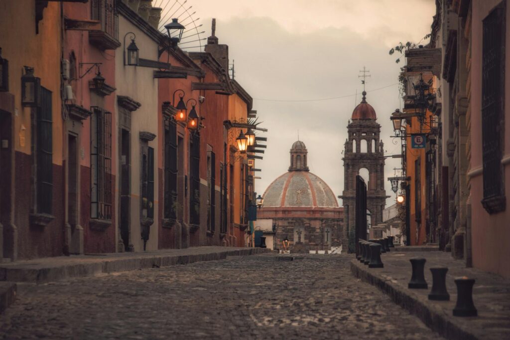 Cobblestone street in San Cristóbal de las Casas at dusk with pastel colonial buildings